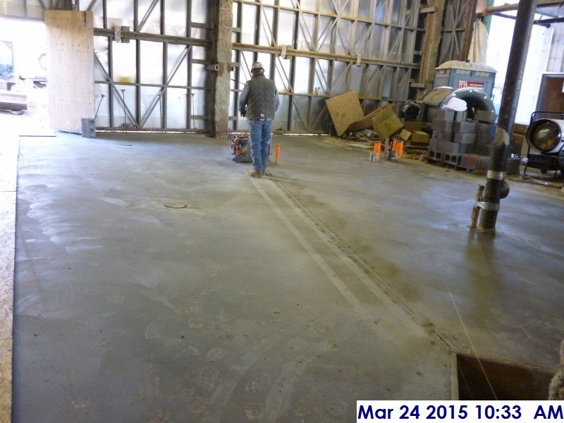 Saw cutting the slab on grade at the Boiler-Electrical Room Facing North